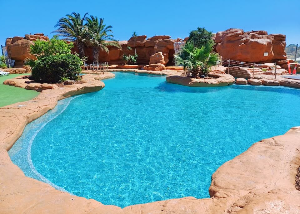 A large pool surrounded by orange cement stone.