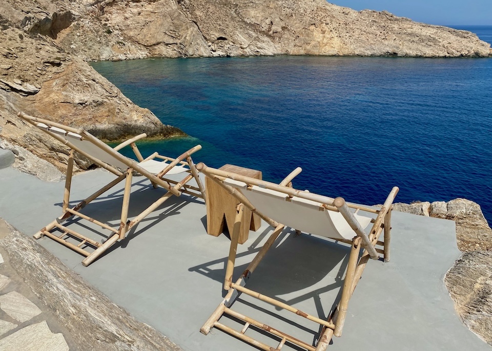 A pair of bamboo and canvas chairs on the edge of an overlook facing out onto the sea at Onar Suites and Villas in Karavostasis, Folegandros.