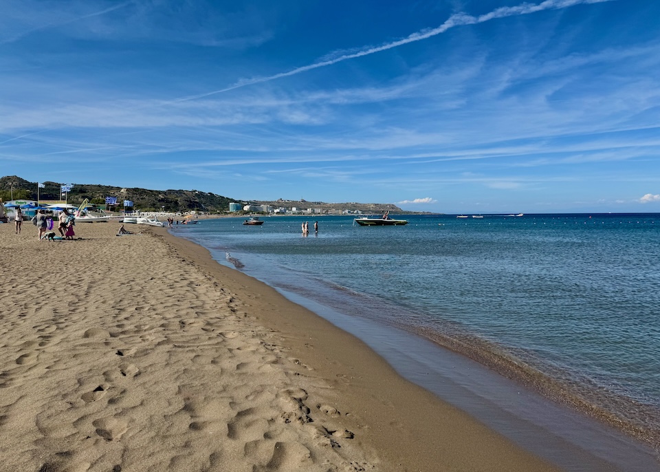 A long, sandy beach with calm waters at Faliraki, Rhodes.