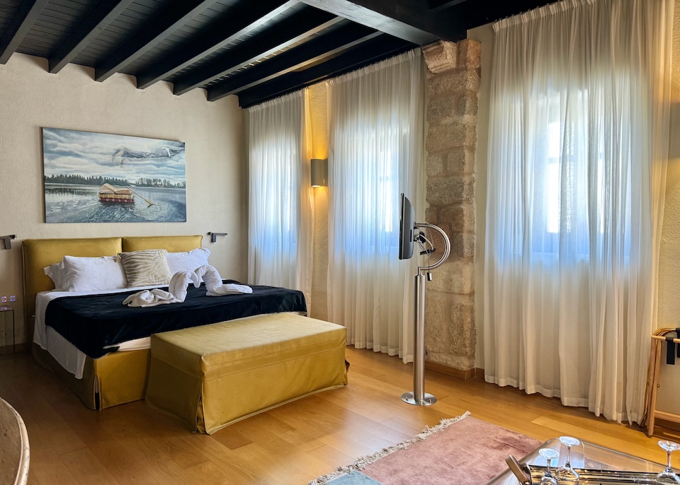 Vintage-inspired decor with original artwork on the walls and an exposed beam ceiling at Allegory Boutique Hotel in Rhodes Old Town.