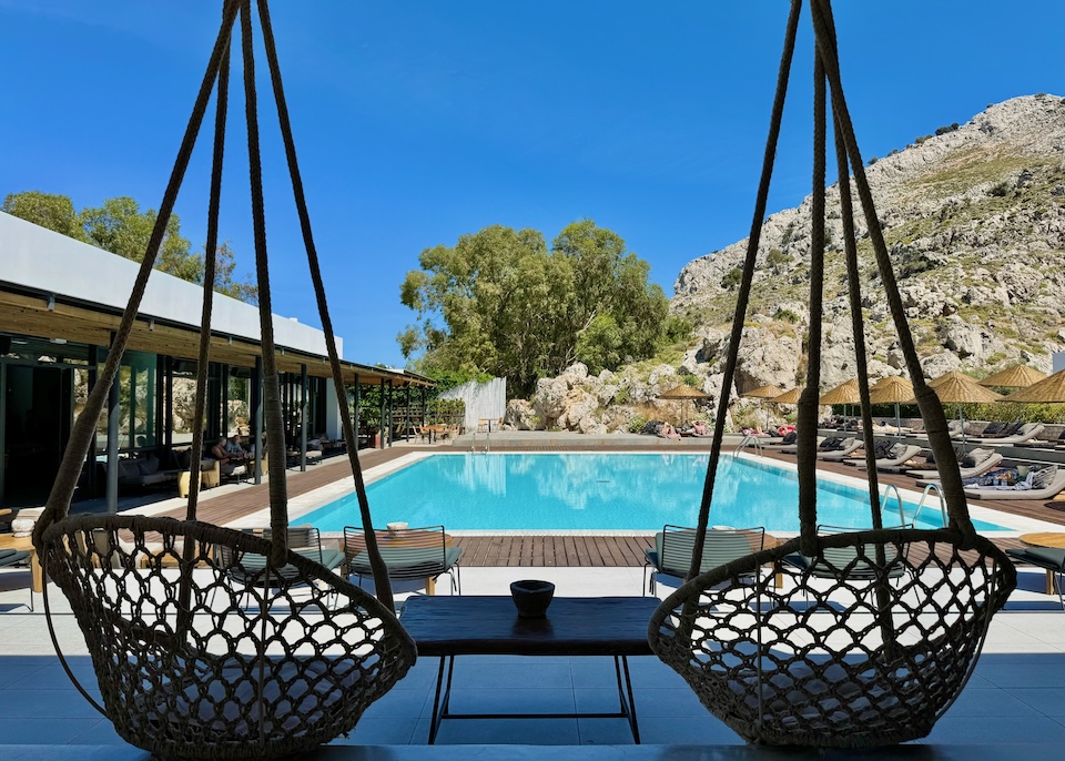 A pair of basket-style swings facing the pool and bar at Casa Cook resort in Kolympia, Rhodes.