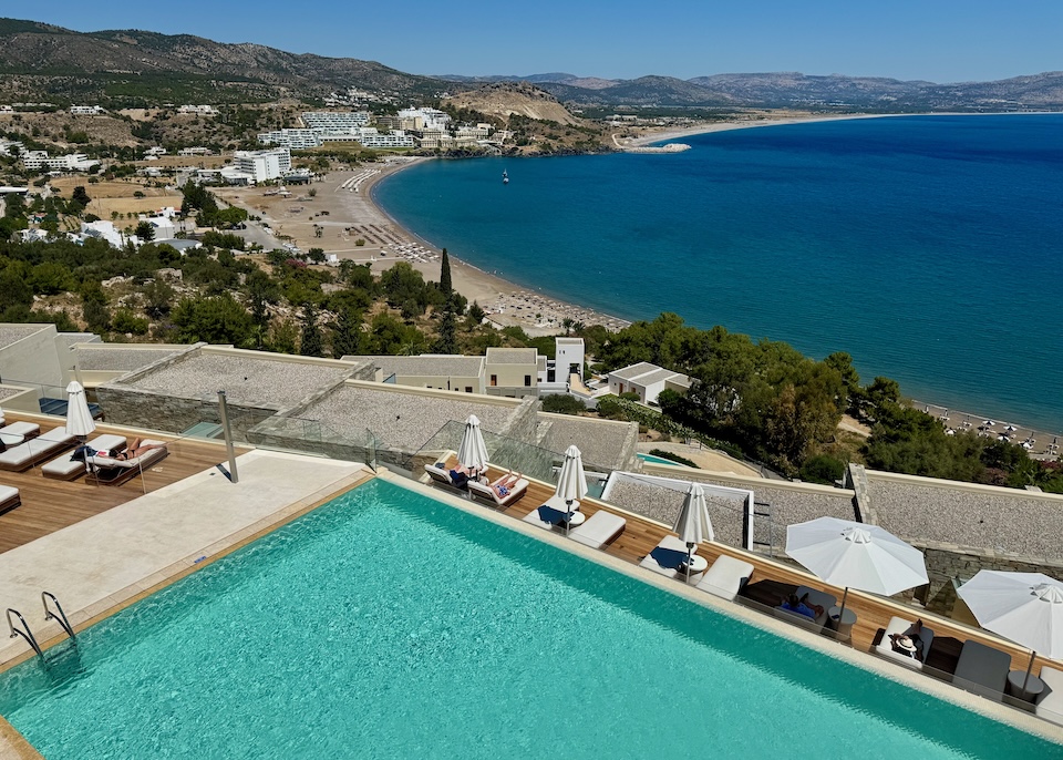 An infinity pool and sun deck perched on a hill above Vlycha Beach at Lindos Blu resort in Rhodes.