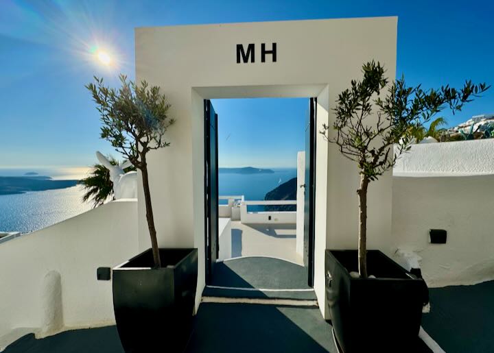 Doorway to a clifftop hotel, showing the Santorini caldera beyond.