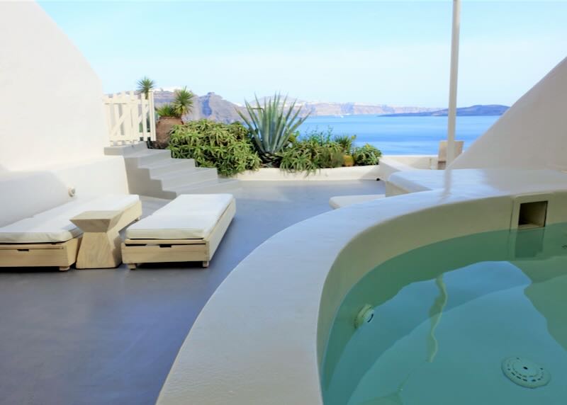 Private plunge pool and sun beds off a hotel suite in Santorini.