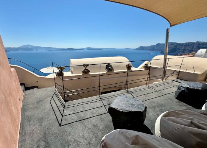 View from afurnished balcony over the Santorini Caldera and the Aegean Sea 