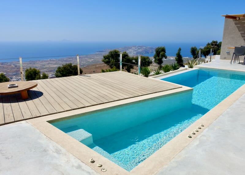 Hotel swim terrace with a view over the Island of Santorini to the sea.