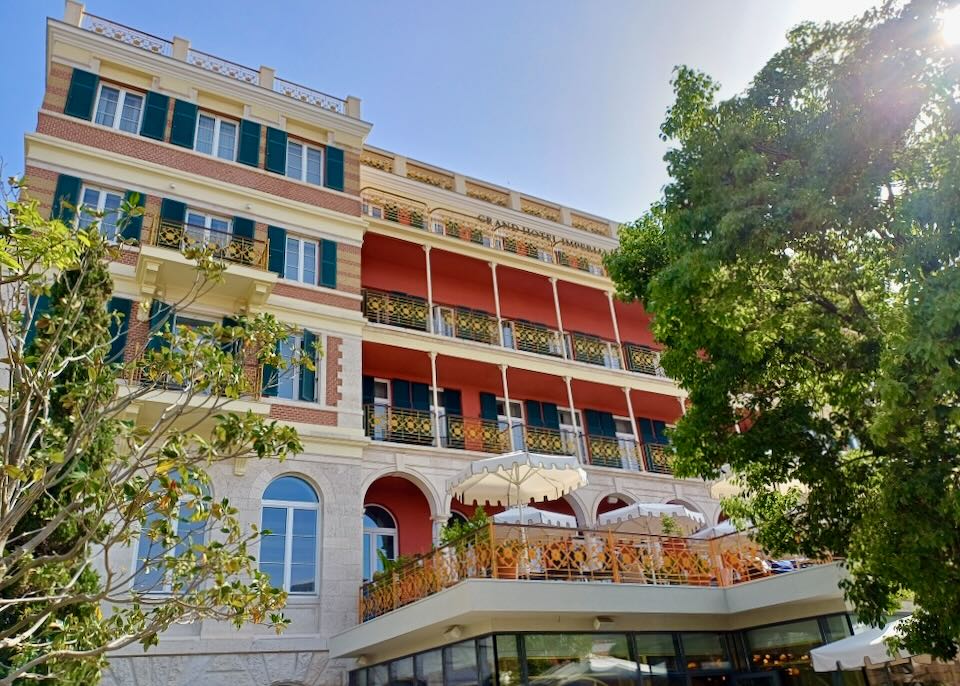 A multi-story hotel with red walls and gold ornate railings.