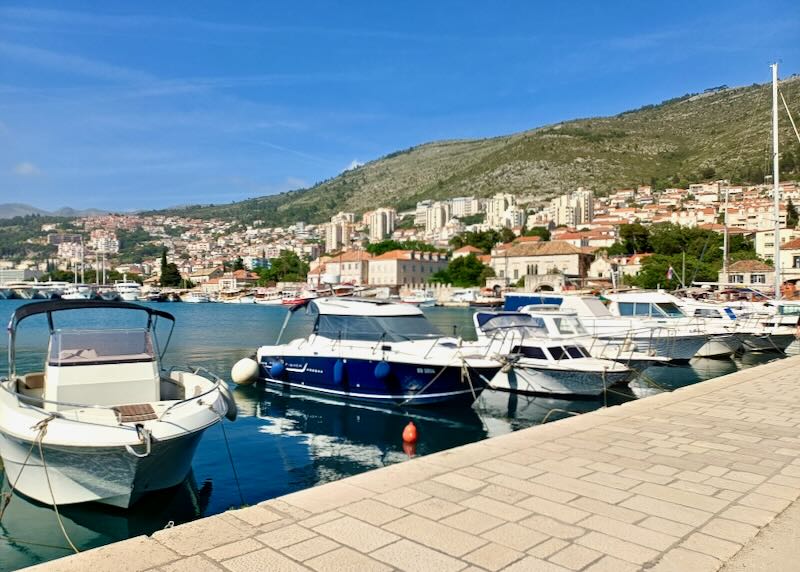 Boats sit roped to a stone walkway.