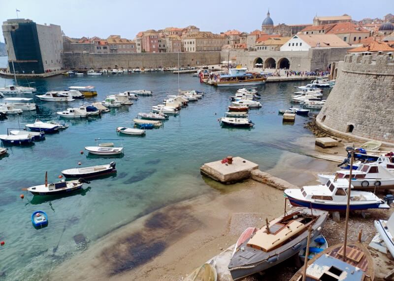 Small fishing boats sit anchored in a harbor.