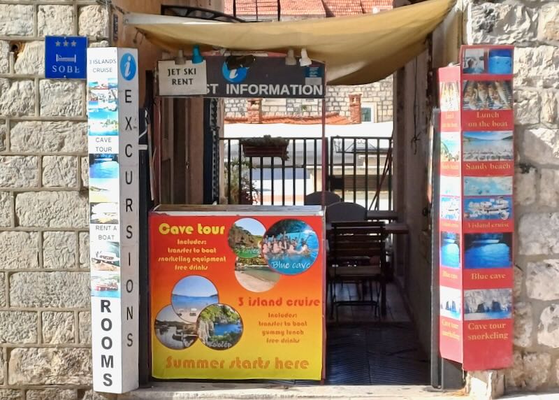 The entrance to a small nook in a stone wall houses a travel agency.