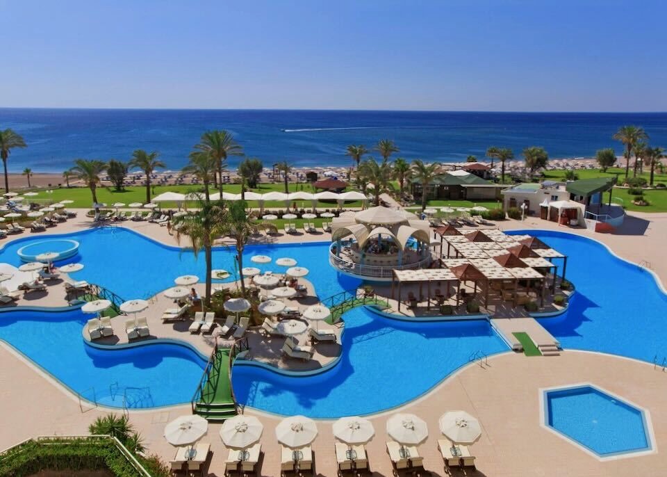 View over a freeform pool toward the beach at Rodos Palladium resort in Rhodes.