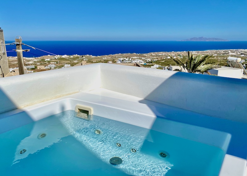 A jacuzzi with a view over the island to the sea at Eternity Hotel in Fira.