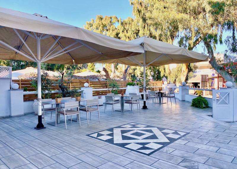 A dining terrace with grey marble stones and a black-and-white geometric design at Eucalyptis Hotel in Mesaria.