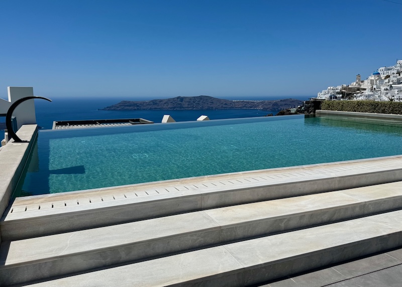 Infinity pool with a view over the caldera and toward Imerovigli village at Aeifos Boutique Hotel in Santorini.