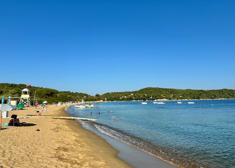 View up a wide golden sand beach on a sunny day