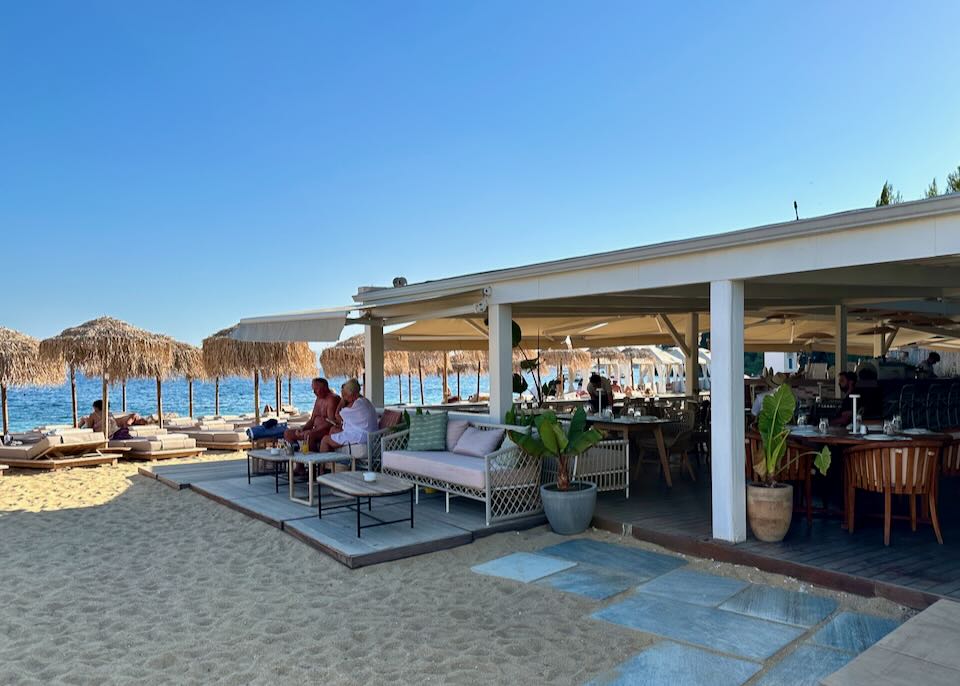 Beach bar with tables spilling into the sand. 