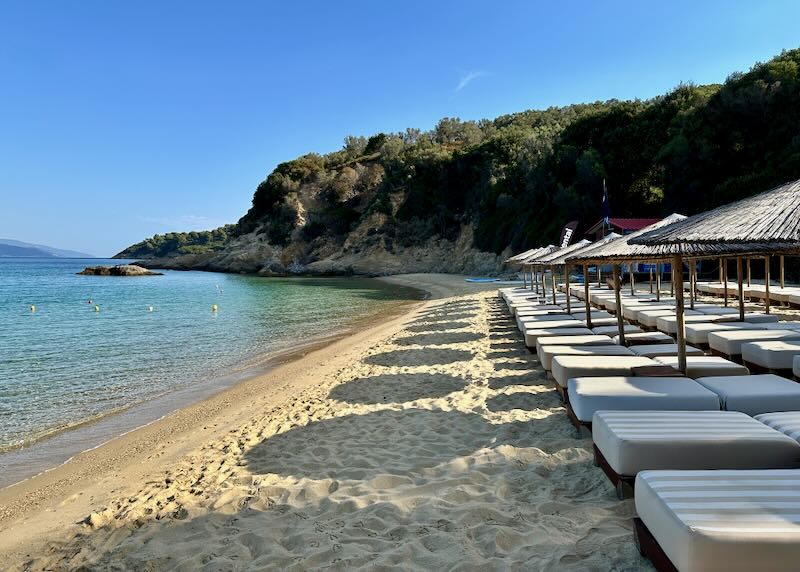 Rows of shaded sun beds on a golden beach