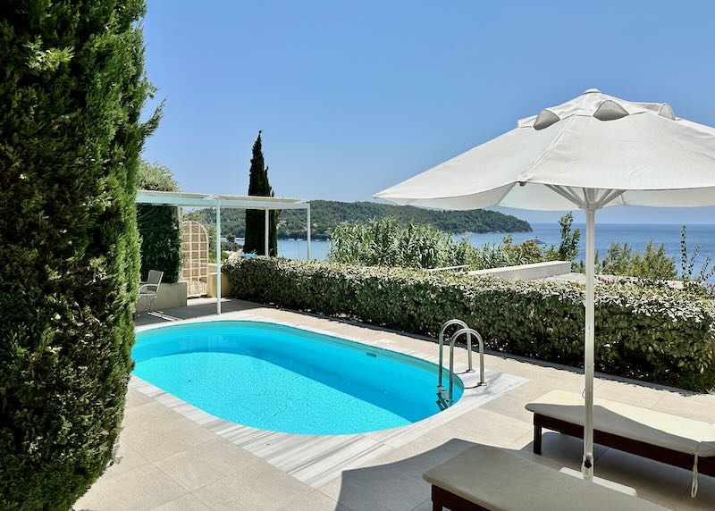 Small swimming pool with sun umbrella, overlooking the sea