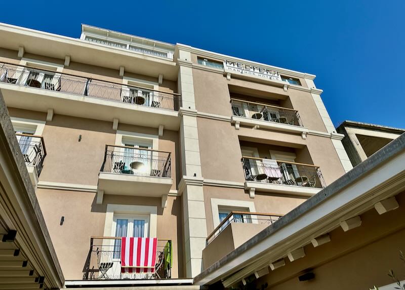 View looking up at a modern hotel with guest room balconies.