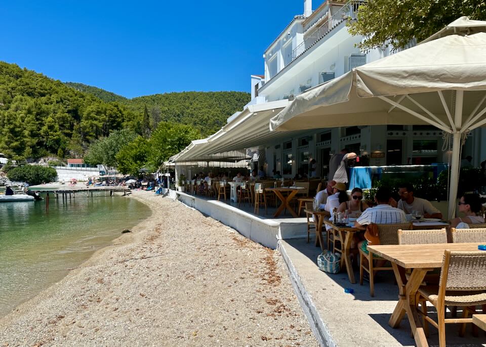 Beach restaurants with rows of tables up against the sand.