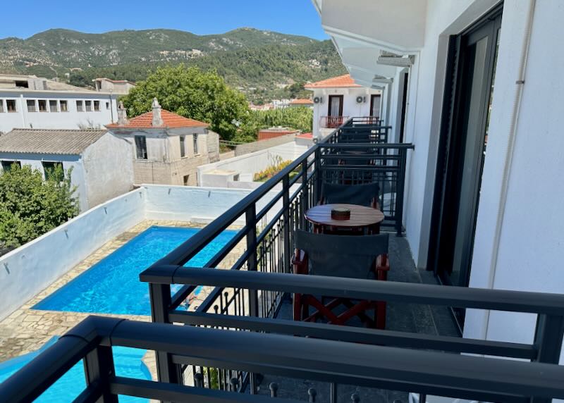 View from a hotel balcony over a pool deck.