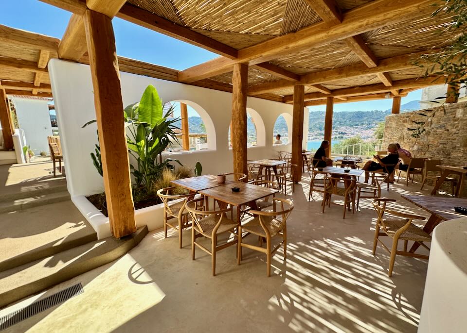 Cafe tables shaded by a wooden-slatted roof on a sunny day