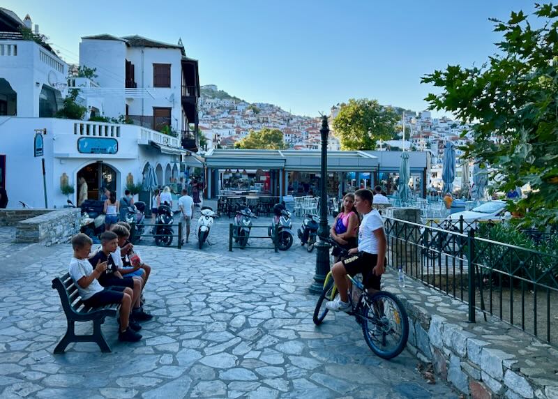 Kids eat ice cream in a stone square in a Greek village