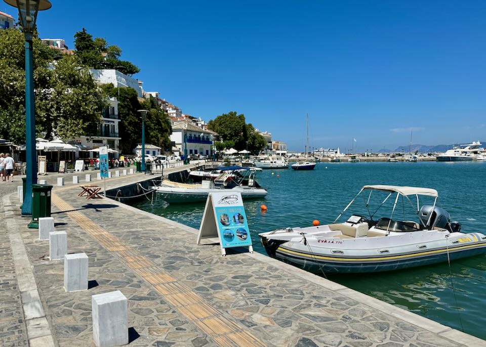 Stone sidewalk lining the seafront, with boats moored alongside