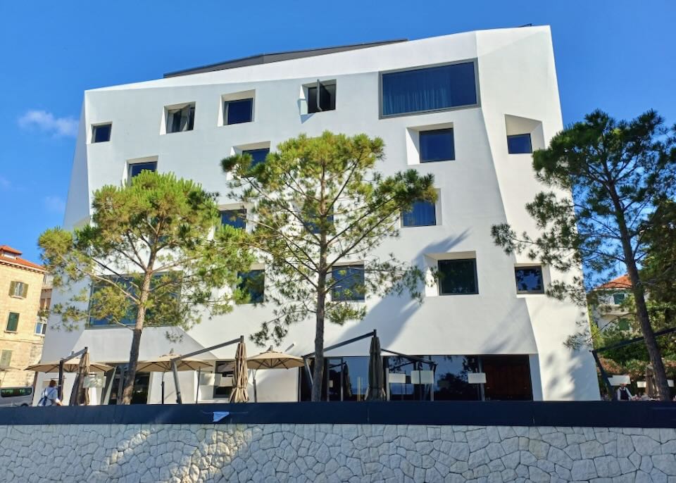 An angular white hotel by the beach.