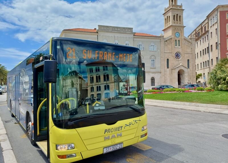 A yellow bus sits on a street.