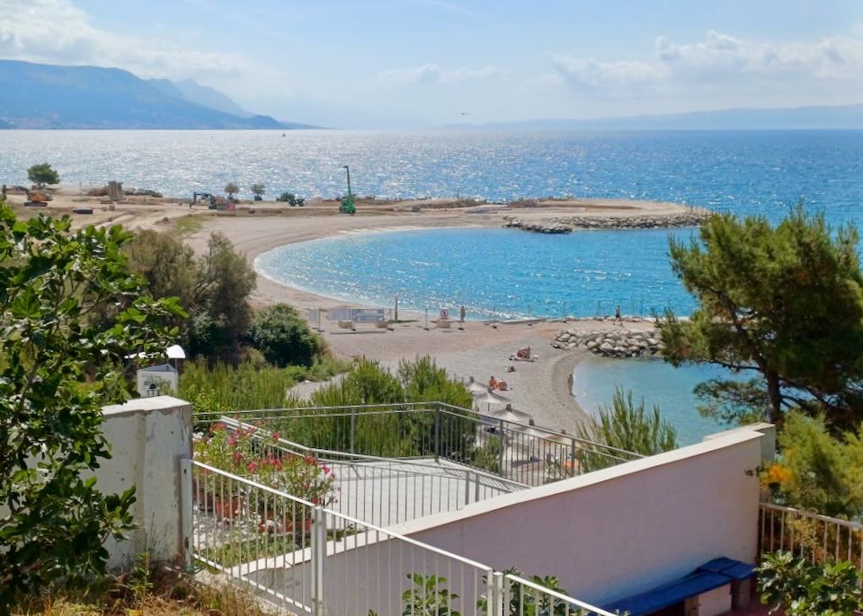 A view from a balcony of two coves on the beach.