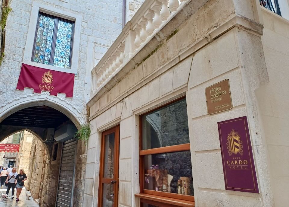 A tight hotel entrance by an arch.