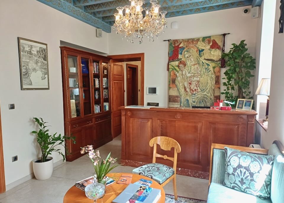 A small lobby with a painting of a woman and a baby behind the desk.