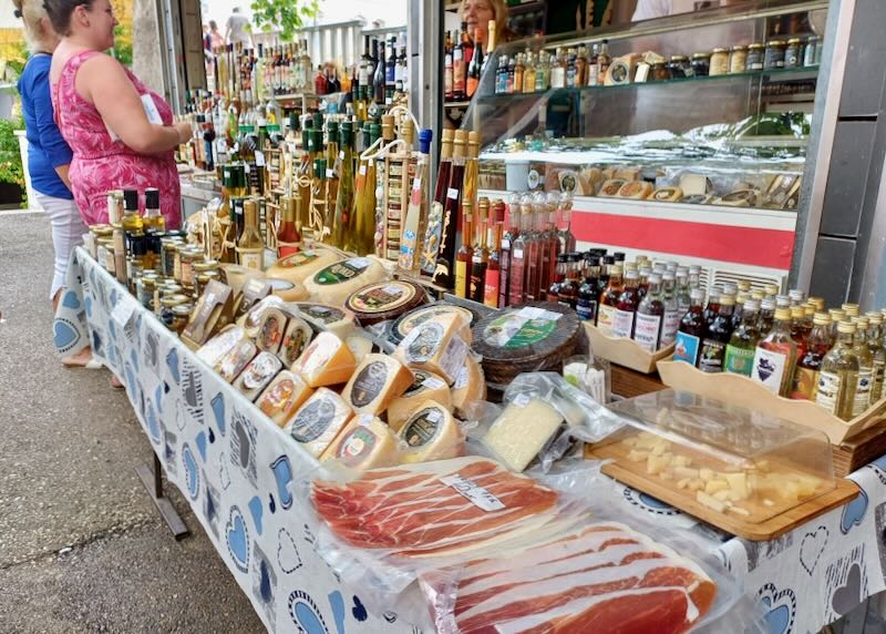 A table displays several cheeses, cured meats, and vinegars.