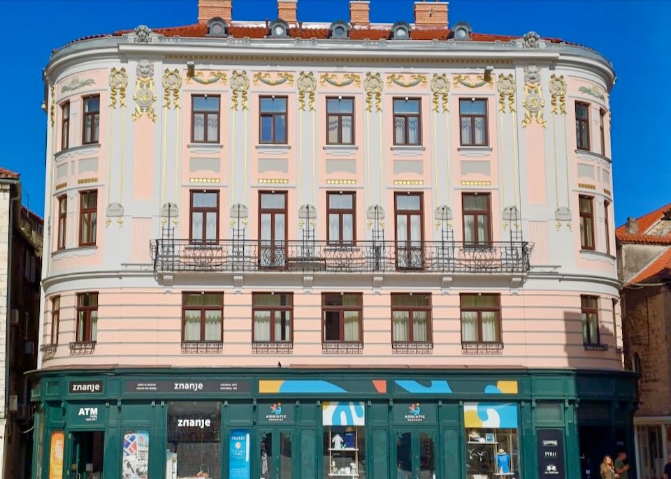 An ornately decorated building with pink paint and gold leaf.