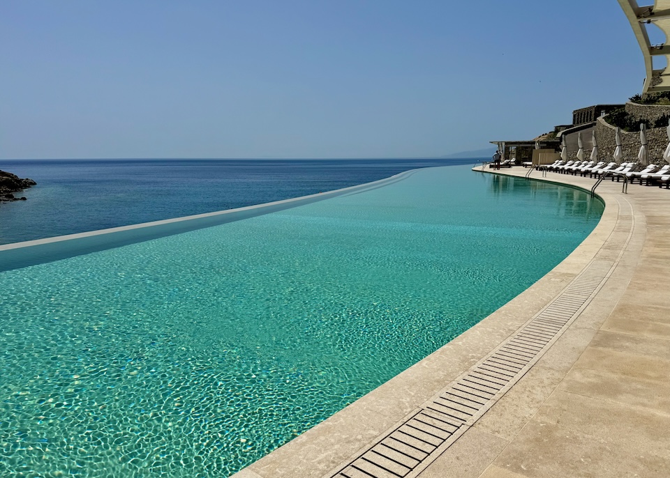 A long infinity pool stretching out into the distance over the sea at Cali near Kalafati Beach in Mykonos.