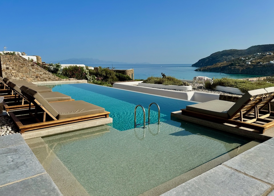 An infinity pool lined with double-sized umbrellas and facing the sea at Mileo near Kalo Livadi Beach in Mykonos.