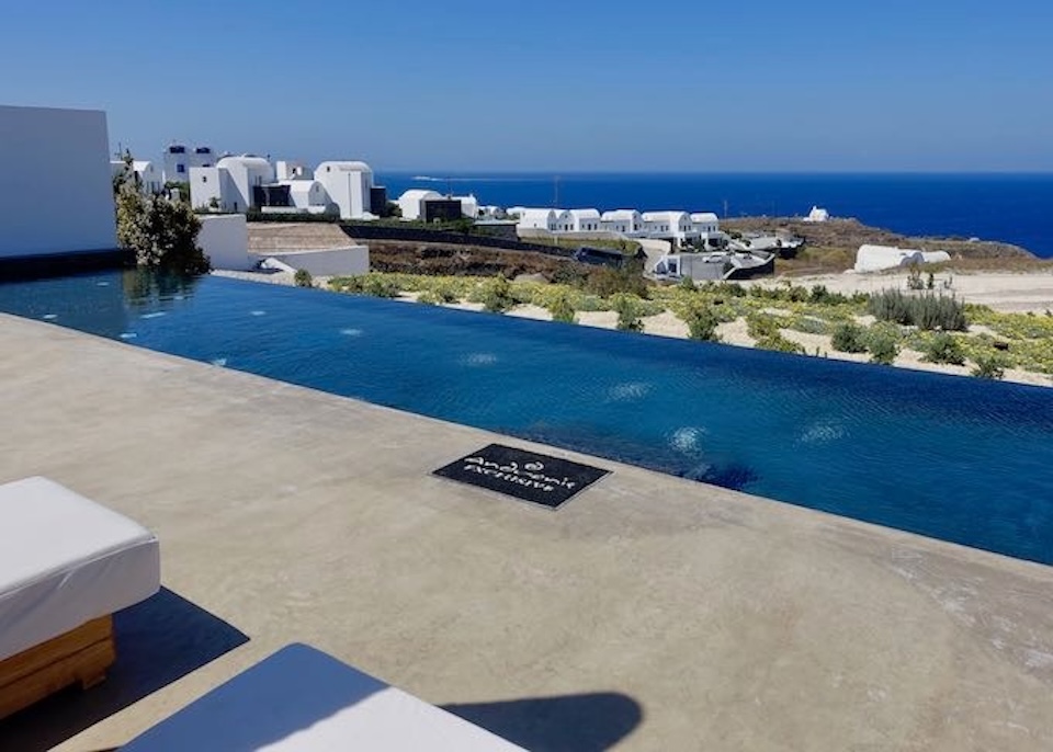 A large, private infinity pool facing out over a vineyard toward the sea at Andronis Arcadia in Oia.