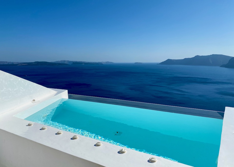 A private, infinity, plunge pool looking out from high above the caldera with the volcanoes in the background at Saint hotel in Oia.