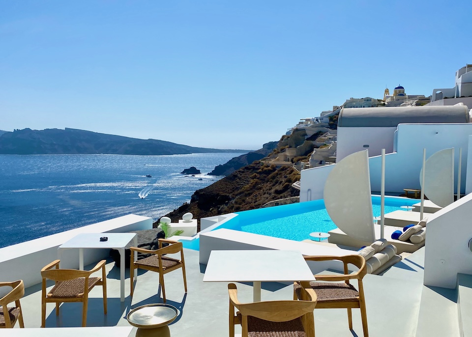 An infinity pool and dining terrace overlook the caldera at the Saint Hotel in Oia, Santorini.