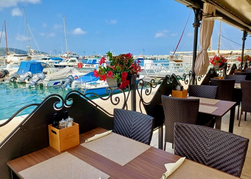 Tables sit by a marina.