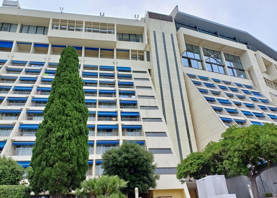 The outside of an angled hotel with balconies.