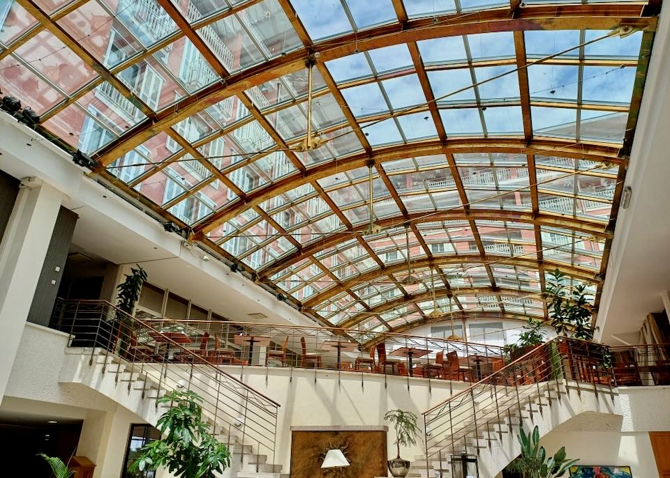 A glass ceiling shows the blue sky.