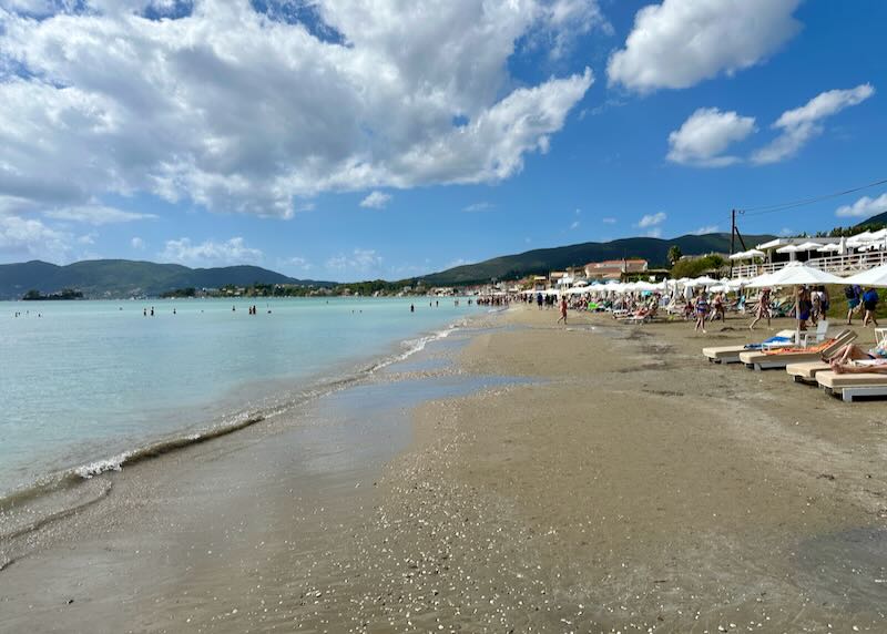 Wide sandy beach lined with sun beds and umbrellas