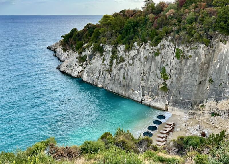 Overhead view of a small sandy beach in a picturesque cove in Greece