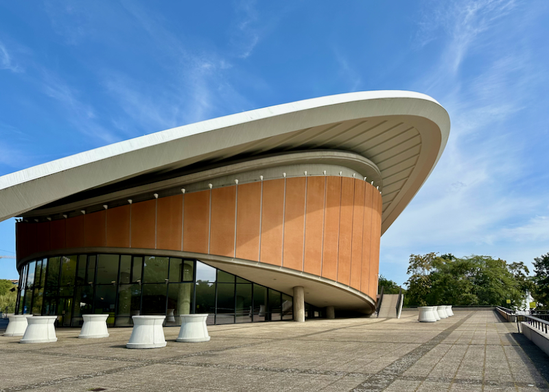 Striking disc-shaped sloped building against a blue sky