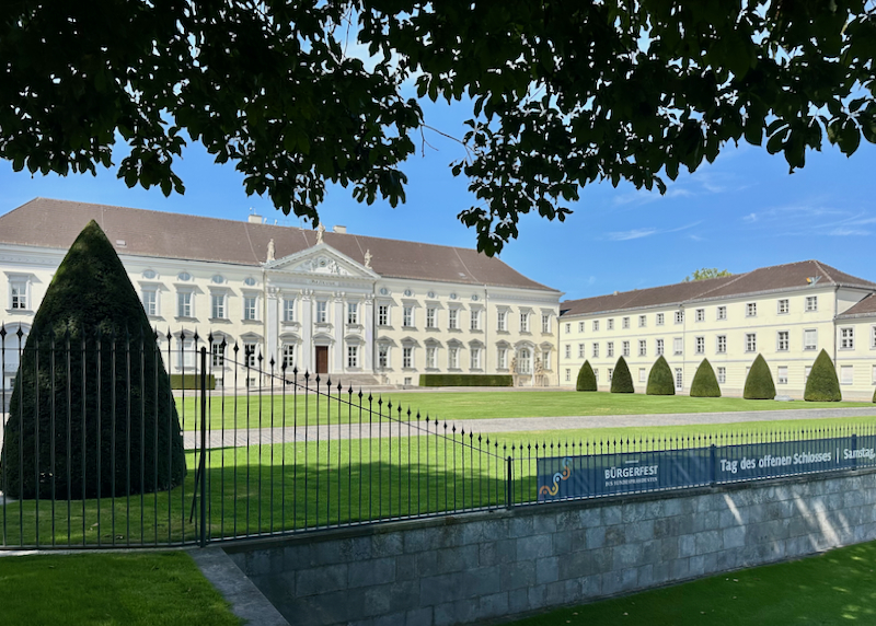 Large white neoclassical palace building behind an iron gate
