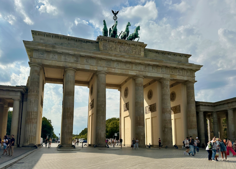 Tourists take photos in front of the giant Brandenburg Gate in Berlin