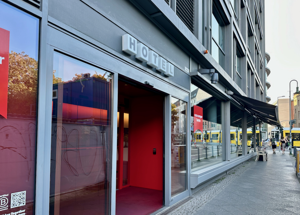 View looking down the sidewalk past the entrance of a modern mid-range hotel