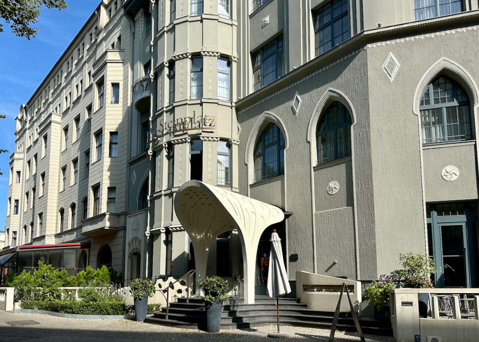 Hotel with a swoopy white awning covering the front steps